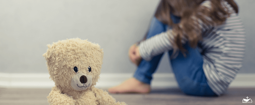 HHRC-Psychological health concept. A teddy bear and in the background a teenage girl out of focus